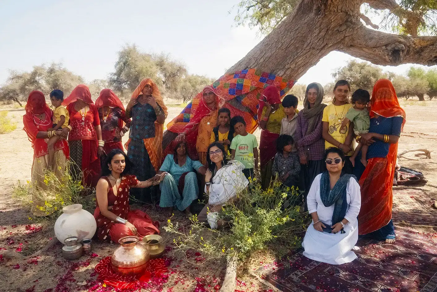 Alt text: taken for Fearless Foundation for the Arts, a group of people in traditional clothing posing in front of a tree. Image credit: Fabrice Bourgelle.